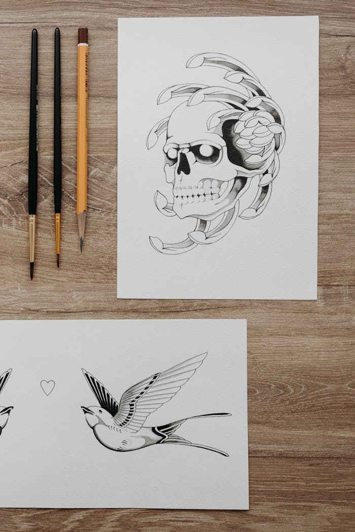 Intricate tattoo design sketches featuring a skull and a swallow, perfect for arts and crafts inspiration.